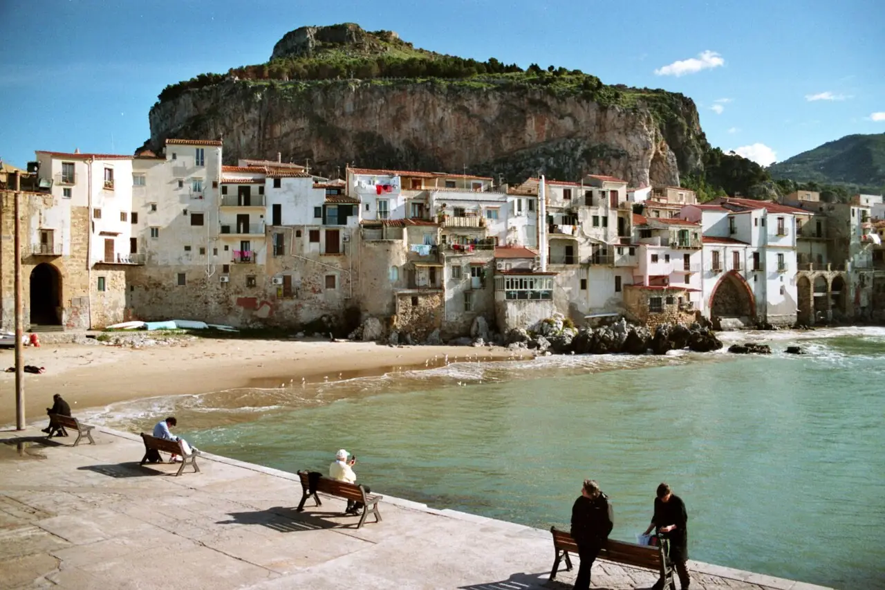 Cefalù, la spiaggia e le case del centro storico sotto la Rocca