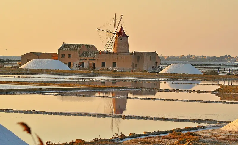 Le saline di Trapani con il mulino a vento al tramonto